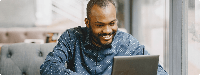 Smiling man using laptop for seamless booking